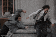 two men in suits and ties are fighting on a carpet