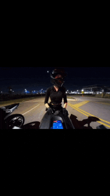 a woman is riding a motorcycle down a highway at night .