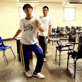 two boys are dancing in a classroom and one has a shirt that says forty