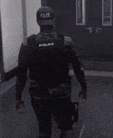 a police officer is walking down a hallway in a video game while holding a gun .
