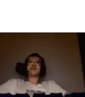 a man wearing headphones and glasses is sitting in a dark room