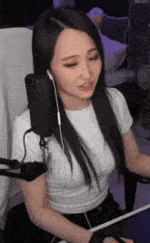 a woman is sitting in front of a microphone with headphones on .
