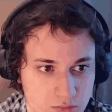 a close up of a man wearing headphones and making a funny face .