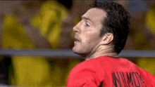 a man wearing a red shirt with wilmots on the back