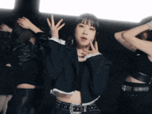 a woman in a crop top and a black jacket is dancing