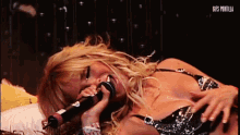 a woman singing into a microphone with gifs tortilla written on the bottom right