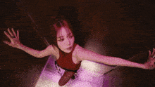 a woman in a red dress is standing in an elevator with her hand outstretched .