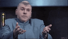 a man in a blue suit is making a funny face while pointing at the camera ..