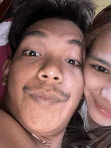 a close up of a man 's face with a woman in the background