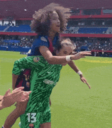 a female soccer player wearing number 13 is carrying another player on her back