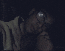 a person wearing glasses with a reflection of the letter r on the lens