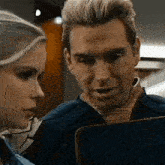 a man and a woman are looking at a folder together .