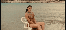 a woman sits on a chair in the water