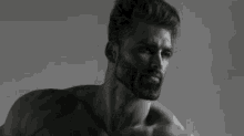 a black and white photo of a shirtless man with his arm up in the air .
