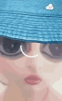 a close up of a woman wearing a blue hat and sunglasses .