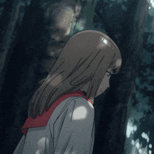 a girl with a red scarf around her neck is standing in the woods