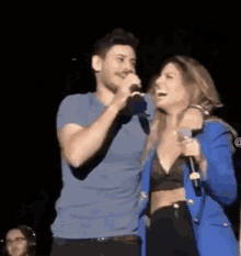 a man and a woman are standing next to each other on a stage .
