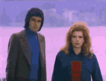 a man and a woman are standing next to each other in a field