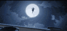 a silhouette of a person flying through the air with a full moon in the background