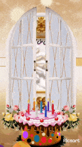 a birthday cake with candles and flowers in front of a window that says picart