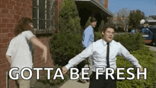 a man in a suit and tie is dancing on a sidewalk .