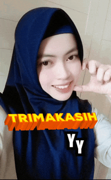 a woman wearing a blue hijab with the words trima kasih yy written on it
