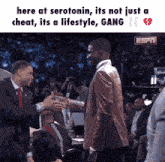 a man in a suit shakes hands with another man in a suit and tie
