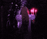 a woman in a white dress is holding a candelabra with pink candles on it