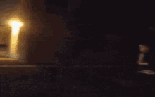a person is doing a trick on a skateboard in front of a building at night
