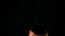 a man in a black shirt is standing in the dark