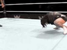 a person is kneeling down in a boxing ring with a w logo in the background