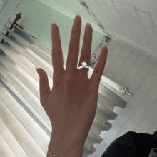 a woman 's hand with a diamond ring on her finger