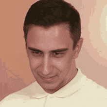 a close up of a man 's face wearing a white polo shirt