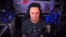 a man wearing headphones is sitting in front of a microphone and a keyboard