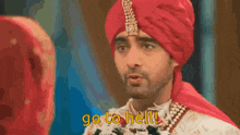 a man wearing a red turban is pointing at a woman and says go to hell