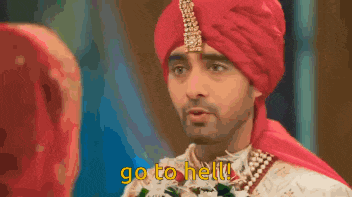 a man wearing a red turban is pointing at a woman and says go to hell