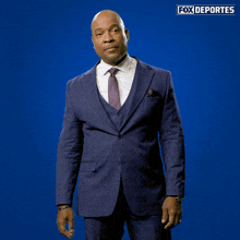 a man in a suit and tie is standing in front of a blue background with fox deportes written on it