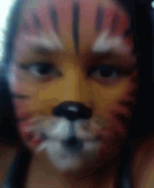 a woman has her face painted to look like a cat