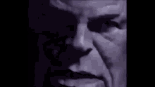 a close up of a person 's face in the dark with a shadow of a person .