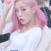 a woman with pink hair is sitting in a chair