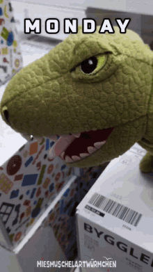 a picture of a stuffed dinosaur with monday written above it