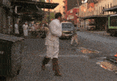 a man in a white apron is walking down a street with a garbage can that says ' a ' on it