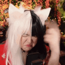 a woman wearing a fox ear wig is holding a cell phone