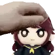 a hand is holding a stuffed doll 's head .