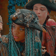a woman with blue braids wearing a hat with a starfish on it