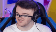 a man wearing glasses and headphones is making a face
