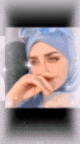 a blurry picture of a woman wearing a blue hijab .
