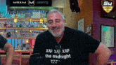 a man wearing a black shirt that says the midnight on it