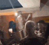 a woman in a white dress is dancing in a room with other people