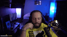 a man with a beard wearing headphones and a yellow shirt that says d8